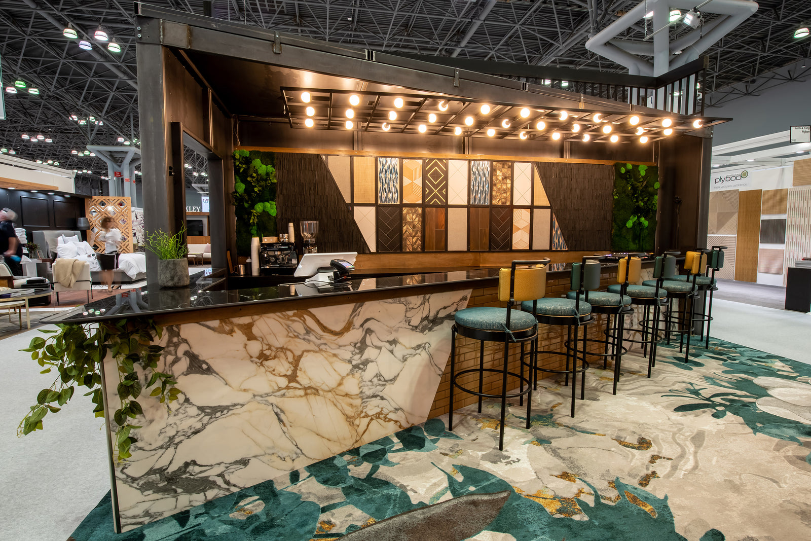 Architessa trade booth at a tile tradeshow event, large tile samples on a backsplash behind a marble look counter